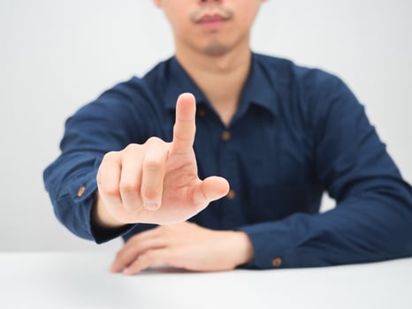 Businessman sitting at the desk show finger push button white background photo