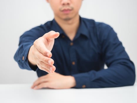 Man giving hand for handshake at the table photo