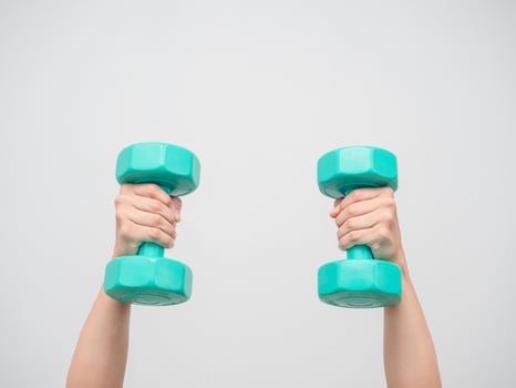 Hands holding green dumbbell white isolated photo