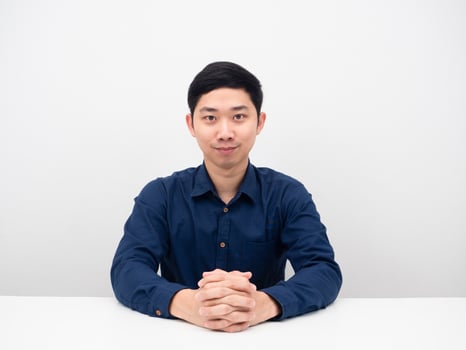 Handsome man sitting at the desk feeling confident with smile looking at you photo