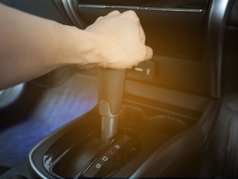 Hand catch at gear auto of car interior the car with light flare photo