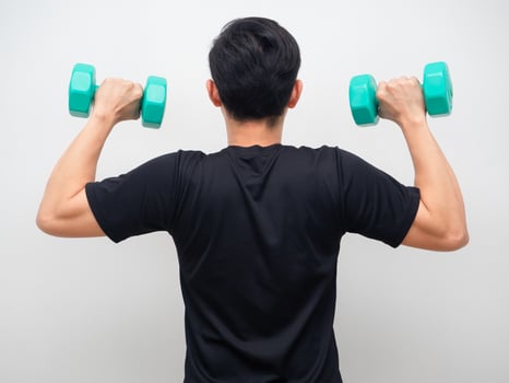 Man holding drumbbell for workout stand turn back photo