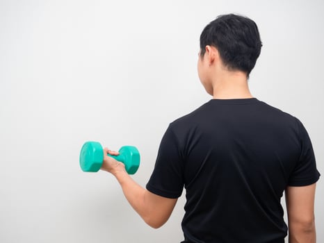 Man holding drumbbell for workout stand turn back photo