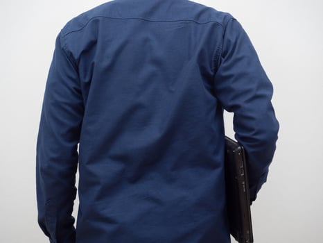 Man turn back holding laptop in hand photo