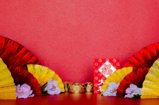 Red envelope packets or ang bao word mean wealth, lucky and ingots with golden and red oriental fans with peach blossom on red background for Chinese new year concept. photo