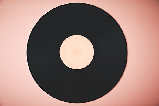 Old retro vinyl disc on the pink background. Vintage toned photo