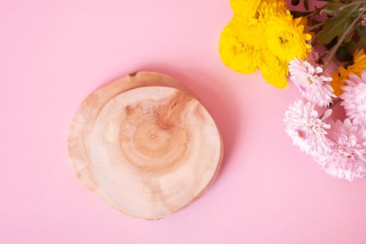Wooden podium or pedestal with chrysanthemum flowers top view. Mockup for your cosmetic products photo