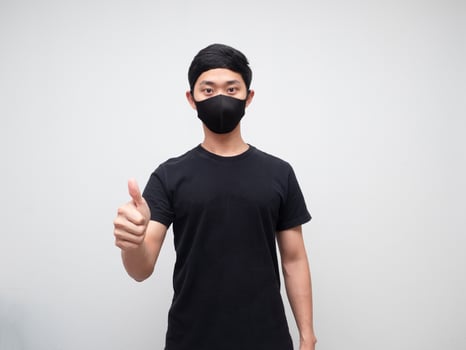 Asian man wearing protect mask show thumb up looking at camera white background photo