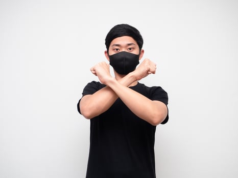 Asian man black shirt with mask cross arm disagree say no looking at camera on white isolate background photo