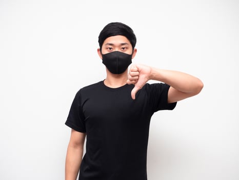 Portrait man wearing mask show thumb down disagree looking at camera white background photo