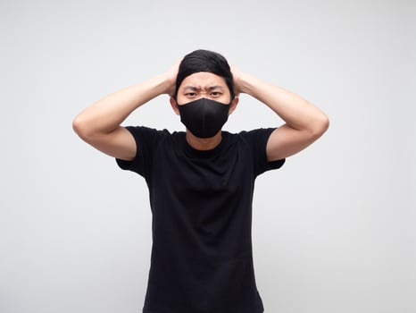 Asian man with mask strain and touch his head on white background photo