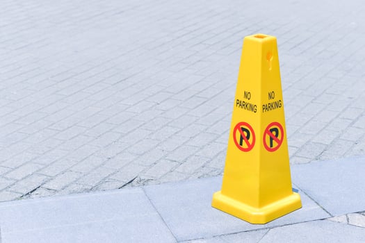 yellow no parking cone on the street photo