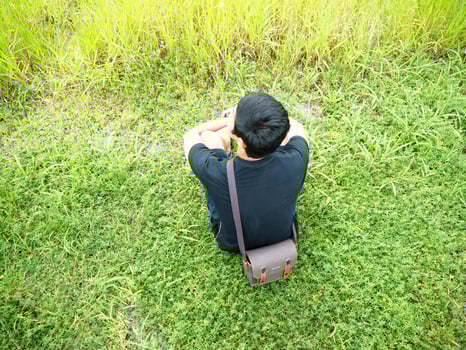 man sit on grass with natural view mountain and lake.man sitting at the green grass on the mountain and looking natural and lake photo