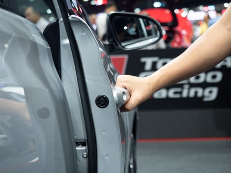 Hand open door car white color and blur event motor show concept photo