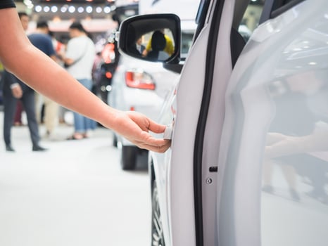 Hand open door car white color and blur event motor show concept photo