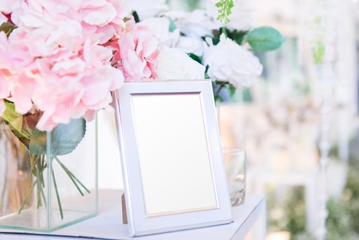 Blank  frame on the table and flower decoration photo