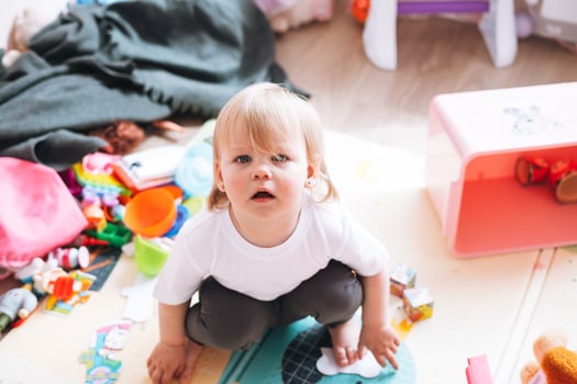 Cute funny baby girl sitting on floor in children room at home photo