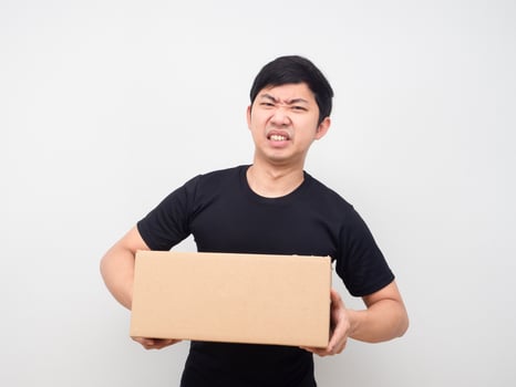 Man holding parcel box feeling heavy white background photo