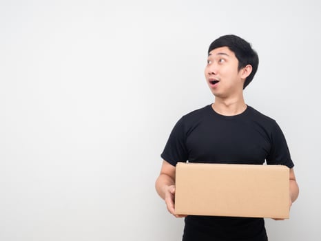 Young man holding parcel box and looking at copy space photo