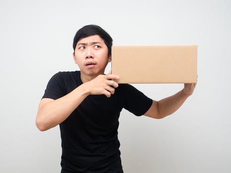 Man feeling excited and listening with the parcel box in hand photo