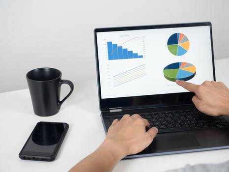 Man hand  working with laptop on the desk with mobile phone and coffee cup photo