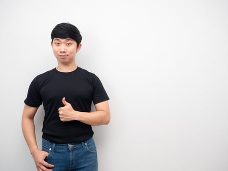 Asian man black shirt thumb up confident looking copy space photo