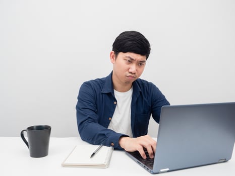 Man using laptop on the desk workplace serious working emotion photo