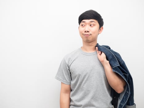 Man holding jean shirt copver body smiling and looking at copy space photo