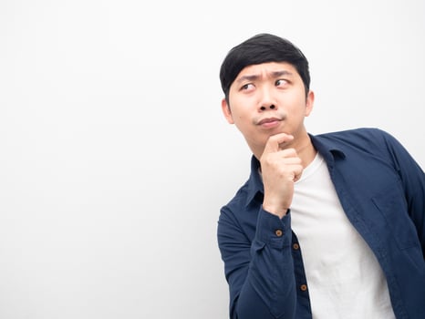 Asian man cheerful gesture thinking with looking at copy space photo