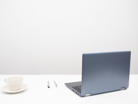 Laptop with coffee cup and pen on the table workplace in the room white background photo