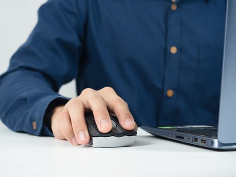 Closeup man hand catch mouse laptop working on the table photo