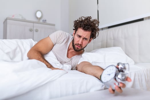 Hate this noise. Problem with early morning awakening. Get up early. Man bearded hipster sleepy face waking up. Daily schedule for healthy lifestyle. Alarm clock ringing. photo