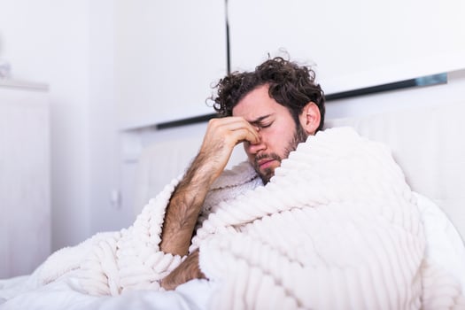 people, bedtime and rest concept - man lying in bed at home suffering from headache or hangover, Sickness, seasonal virus problem concept. photo