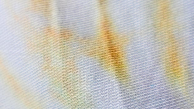 white cloth texture with yellow and blue patterns as background photo