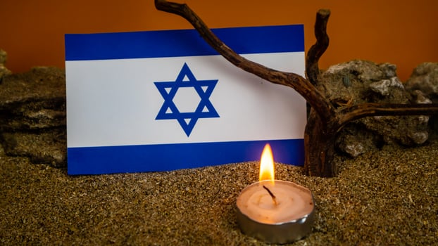 Israeli flag and candles burning in front of it, Holocaust memory day photo