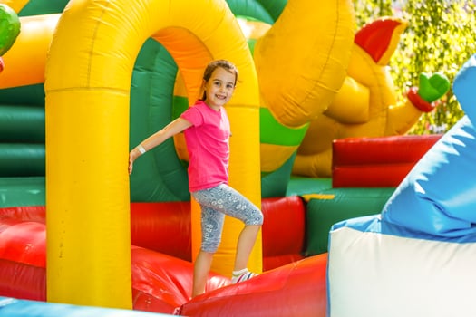 Joyful little girl playing on a trampoline photo