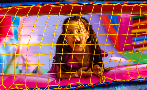Happy little girl having lots of fun on a jumping castle during sliding photo