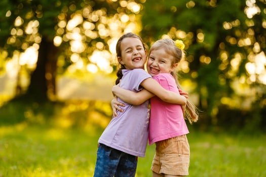 sister girls playing on the green park outdoor photo