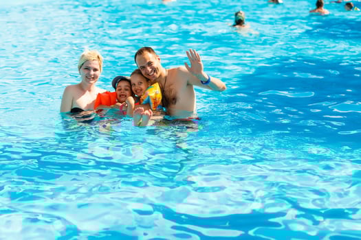 Happy family in the pool, having fun in the water, mother with kids enjoying aqua park, beach resort, summer holidays, vacation concept photo