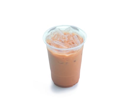 Orange Thai iced condensed milk tea in transparent plastic glass isolated on white background with clipping path photo