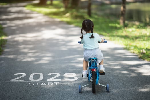 Happy new year 2023,2023 symbolizes the start of the new year. The letter start new year 2023 on the baby girl cycling bicycle on road in nature park garden. Goal of Success. Number 2023 wallpaper. photo