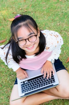 Lovely girl with a laptop on the grass photo