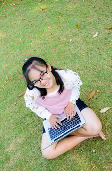 Lovely girl with a laptop on the grass photo
