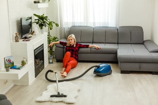 Young woman using vacuum cleaner at home. photo