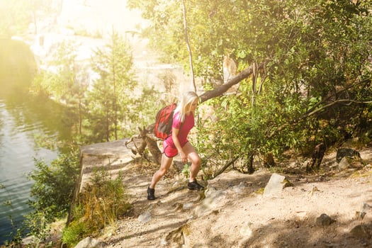 stylish hipster woman with backpack looking at amazing woods and mountains in summer, travel concept, space for text photo