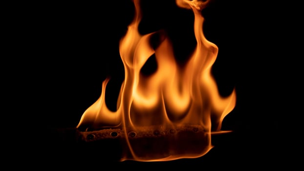 A beautiful shot of a person doing a fire Poi show in the dark photo