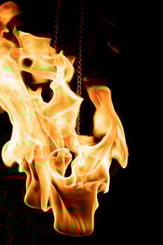A vertical shot of a person doing a fire Poi show in the dark photo
