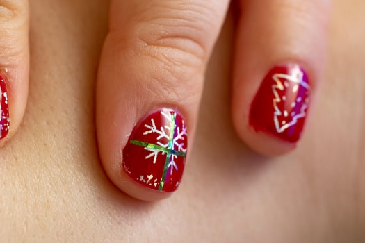 A closeup of red nail manicure design with snowflake photo