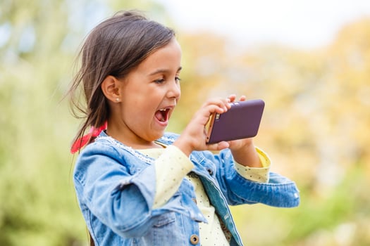 education, school, technology and internet concept - little student girl with smartphone in the park photo