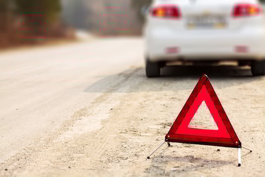 Red triangle sign and automobile on the road, shallow depth of view photo